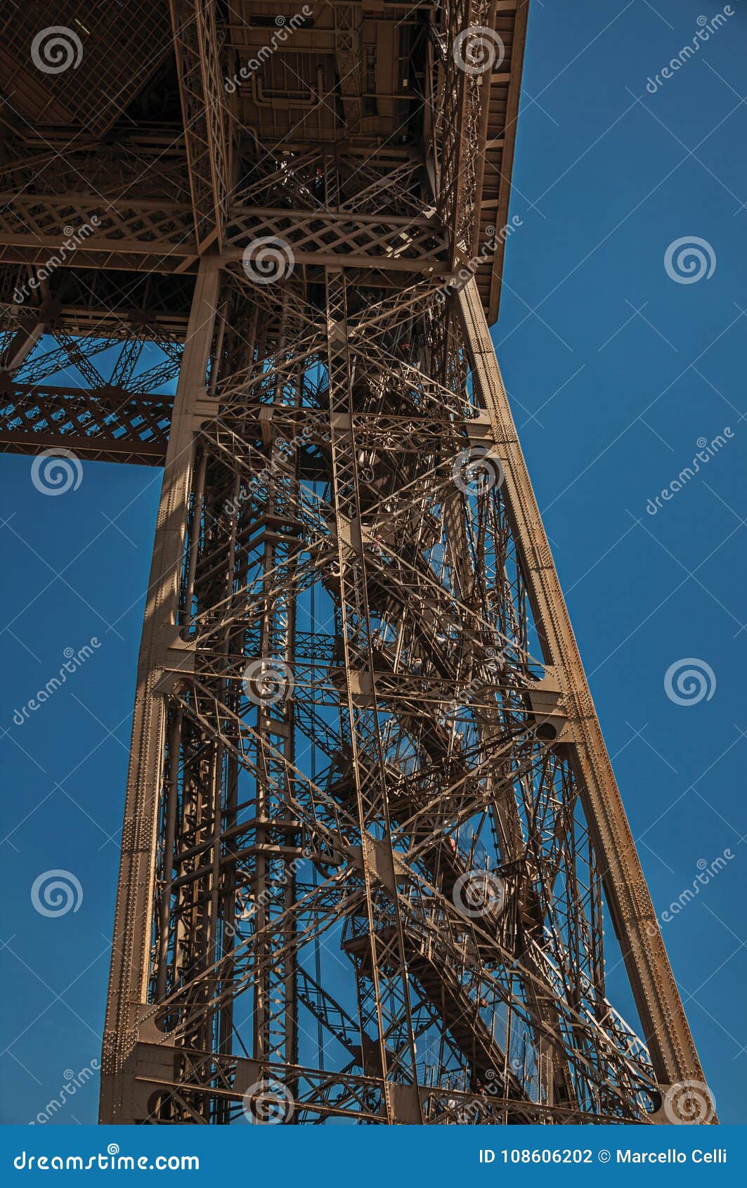 view of one legÃ¢â¬â¢s iron structure of the eiffel tower, with sunny blue sky in paris.